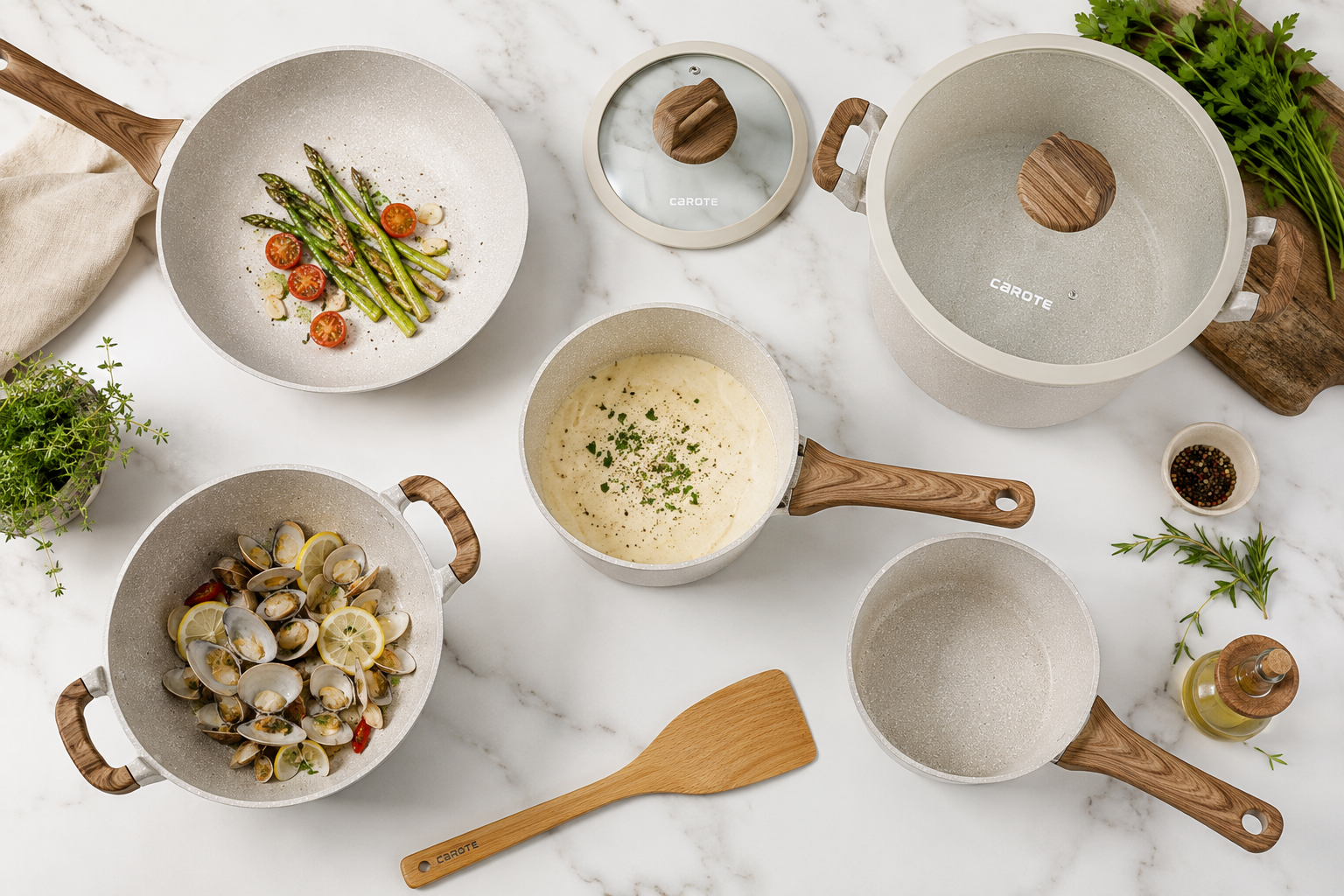Landscape format (1536x1024) detailed flat-lay product photo of Carote granite nonstick cookware set arranged on a white marble surface, showing multiple pan sizes including a skillet, saucepan, and stockpot with distinctive white granite speckled coating and wood-effect handles. Overhead bird's-eye angle, natural daylight, minimalist styling with fresh herbs and a wooden spatula as props. Clean, editorial food photography aesthetic with soft shadows.