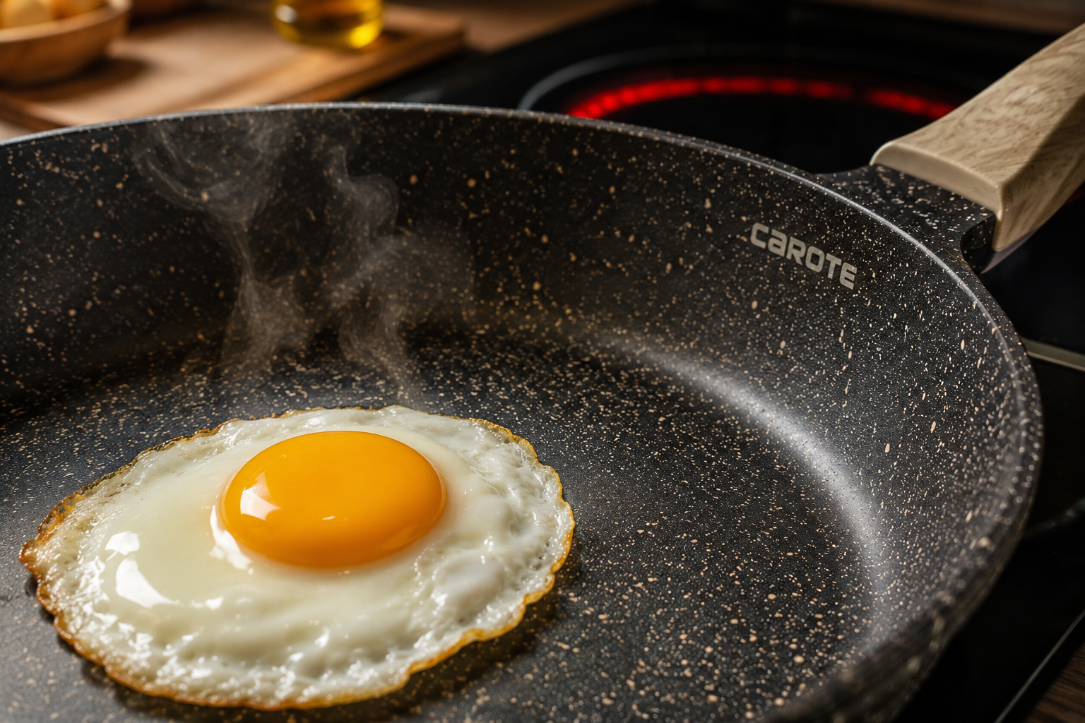 Landscape format (1536x1024) close-up macro photography of a Carote nonstick pan surface showing the granite speckled coating texture in detail, with a single fried egg sliding effortlessly across the surface, steam rising gently. Warm kitchen lighting from the side, shallow depth of field highlighting the nonstick coating quality. In the background, slightly blurred, a kitchen stovetop with induction burner glowing. Appetizing, warm color tones, editorial food photography quality.