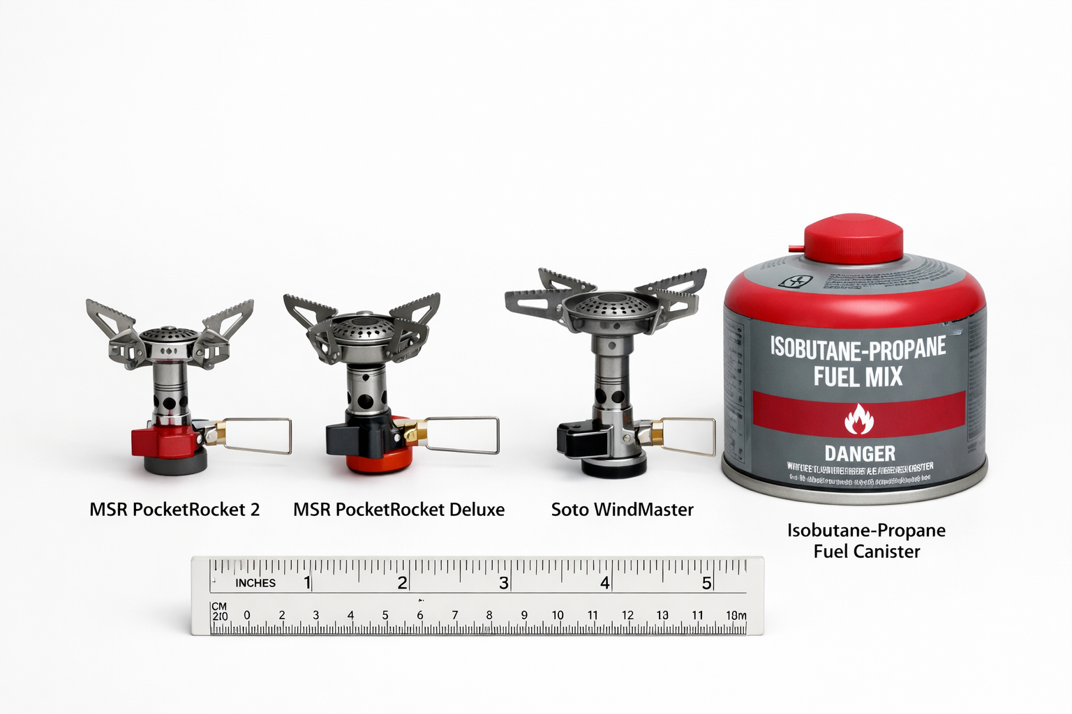 Side-by-side studio photograph comparing MSR PocketRocket 2 and PocketRocket Deluxe and Soto WindMaster canister stoves next to a fuel canis