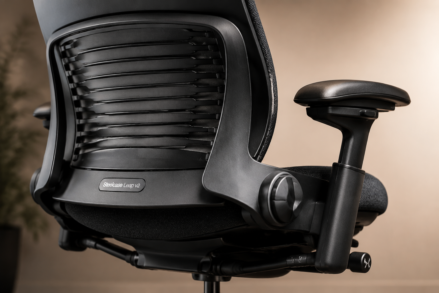Close-up studio shot of Steelcase Leap v2 ergonomic chair showing its distinctive LiveBack flexible backrest and multi-way armrests, with 'Steelcase Leap v2' label visible, warm neutral background, product photography style Steelcase Leap v2: The Long-Haul Sitting Specialist