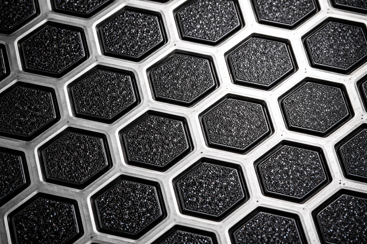 close-up of hexagonal laser-etched nonstick surface pattern showing stainless steel and ceramic coating
