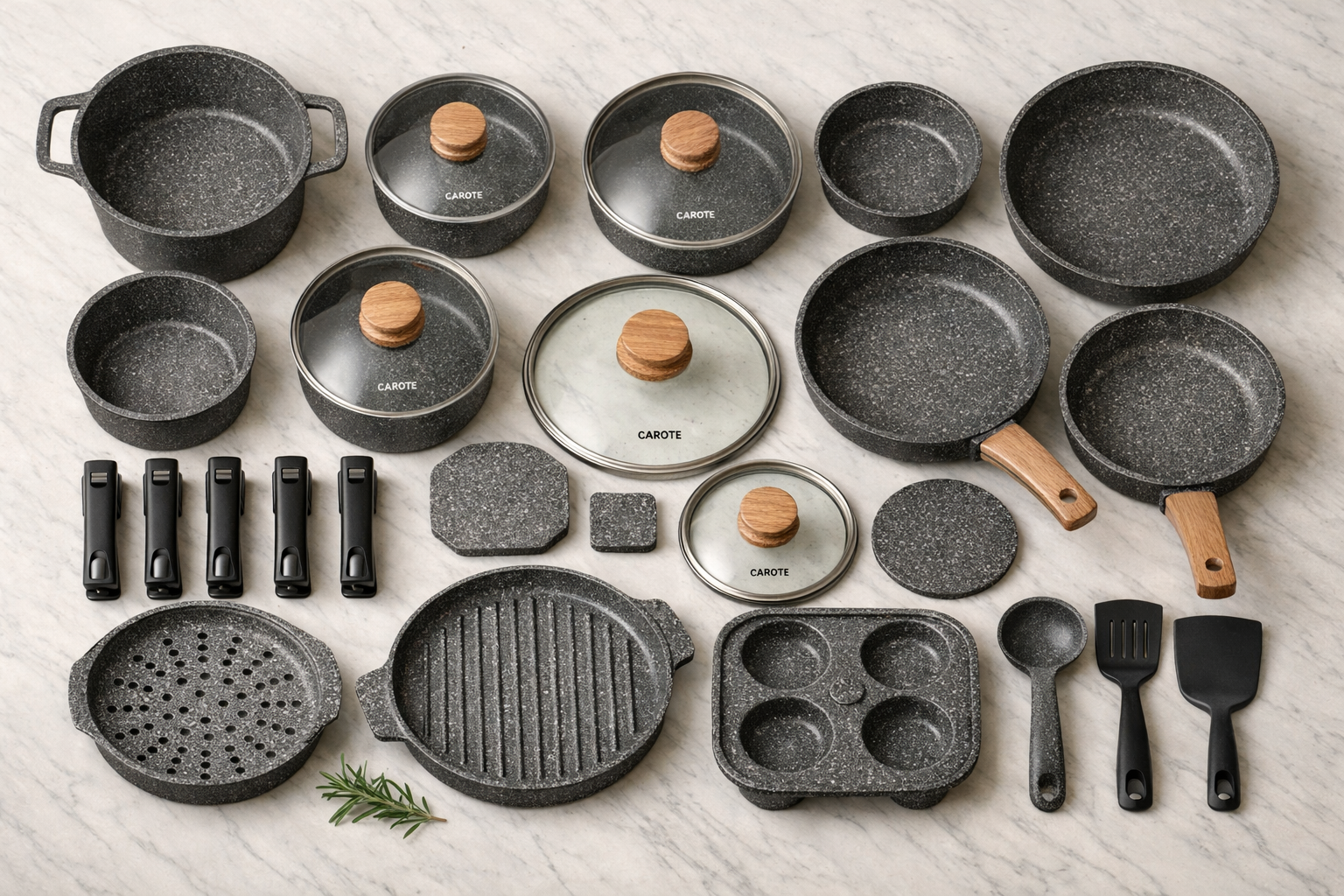 Landscape format (1536x1024) detailed flat-lay photograph of a complete 26-piece Carote cookware set arranged neatly on a light marble countertop, showing pots, pans, lids, and removable handles from a top-down bird's eye perspective. Each piece displays the signature granite speckled nonstick coating. Soft diffused studio lighting, clean minimalist styling with a small herb sprig accent, warm neutral color palette, editorial product photography quality, sharp focus throughout.