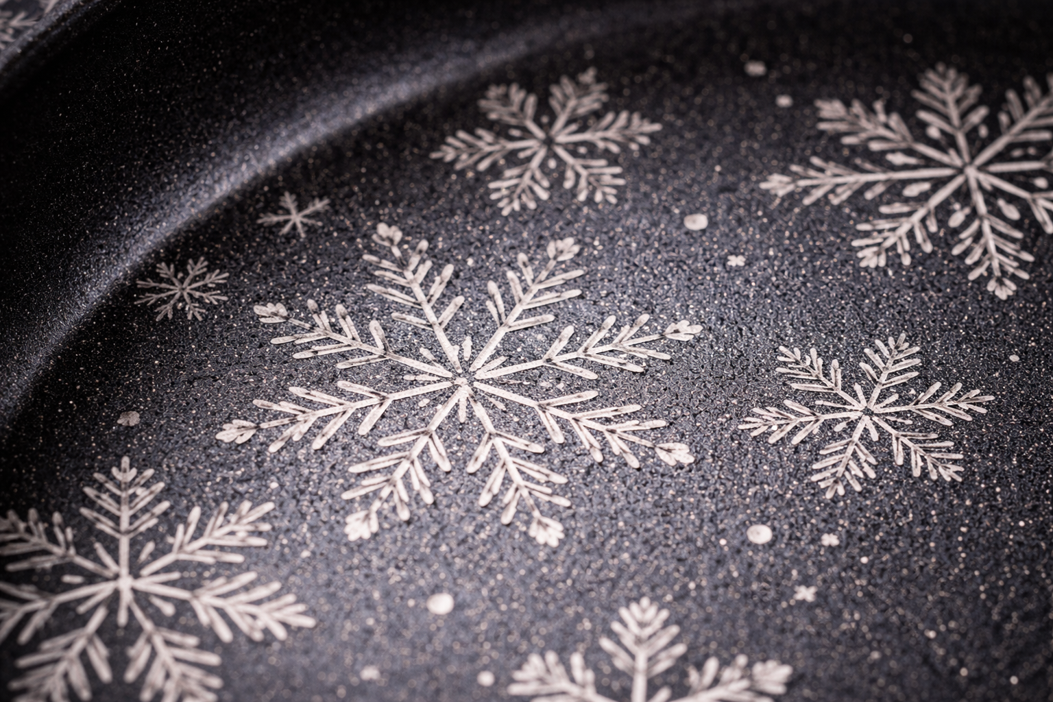 close-up detail of snowflake pattern laser-etched nonstick surface