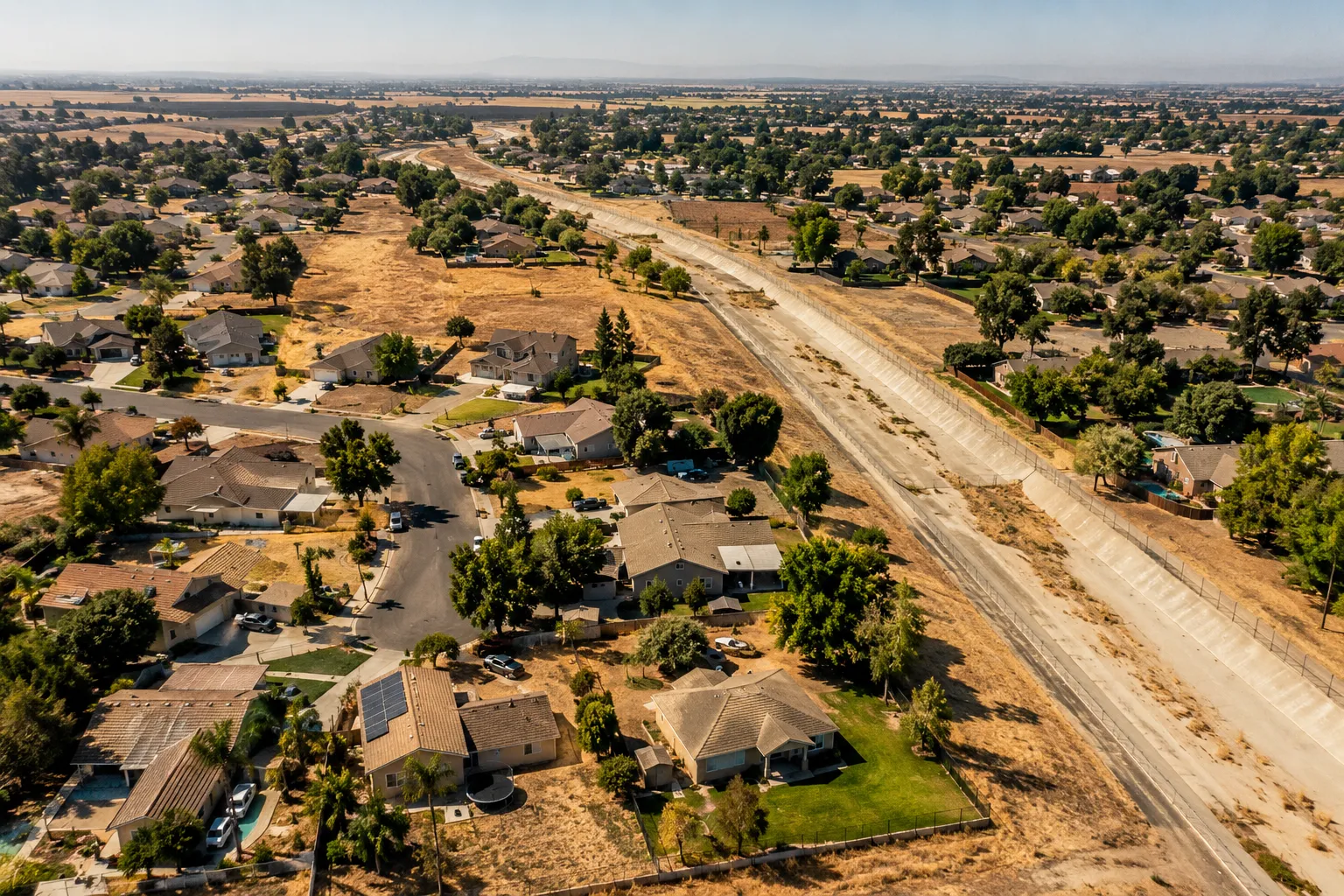Editorial () cover image, no . Aerial drone shot of a sun-baked California suburban neighborhood in the Sacramento Valley,