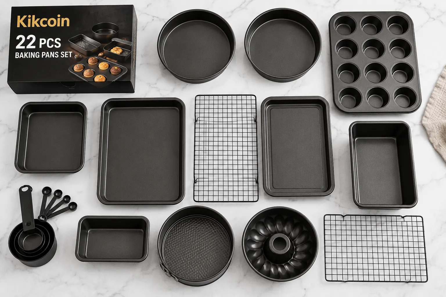 Detailed showcase of the Kikcoin 22 PCS Nonstick Baking Pans Set displaying all 22 pieces arranged in a complete overhead flat-lay on a white marble surface, highlighting the dark nonstick coating, rolled edges, and variety of pan shapes including sheet pans, round cake pans, muffin tin, loaf pan, and cooling racks What Is the Kikcoin 22 PCS Nonstick Baking Pans Set?